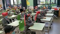 Đaci u Kini vratili su se u školske klupe i nose šešire od jednog metra kako bi održali distancu