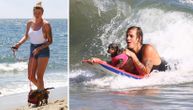 Ćerka Aleka Boldvina uslikana na plaži, dok je njen dečko surfovao sa psom na dasci