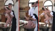 Snimak krštenja iz pravoslavne crkve šokirao: Pop mlatara bebom, ona urla, majka pada u nesvest