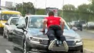Kakav prizor kod Sajma: Muškarac se popeo na haubu auta usred špica i ne silazi, oko njega prolaze vozila
