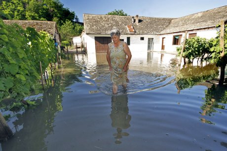 Žena prolazi kroz poplavljeno područje
