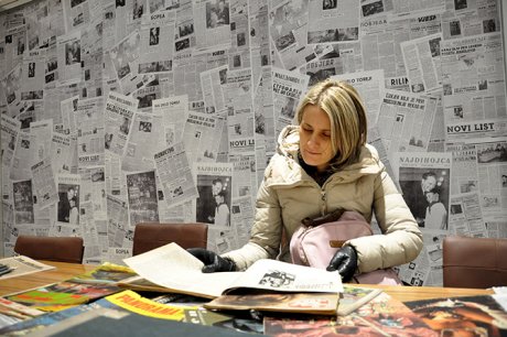 Posetiteljka razgleda novine
