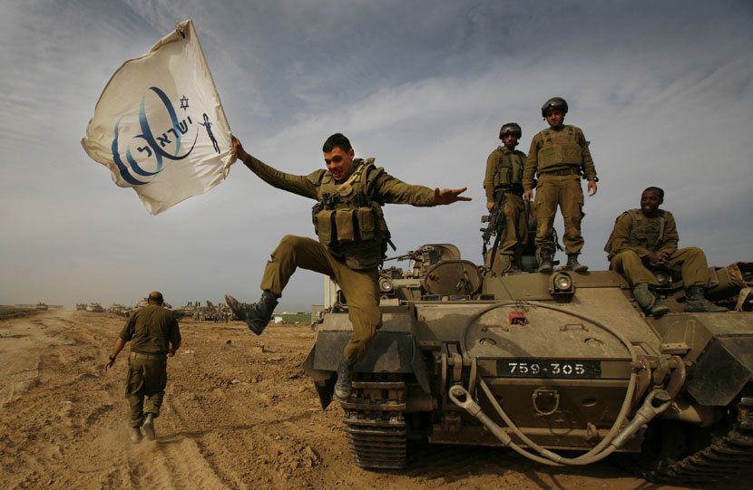 Vojnik skače držeći zastavu 60. godišnjice Izraela, proslavljajući sa svojom jedinicom povratak iz pojasa Gaze