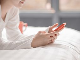 Žena devojka krevet mobilni telefon poruke