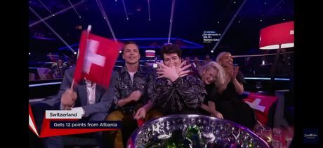 Predstavnik Švajcarske pokazuje dvoglavog orla u finalu Evrosonga
