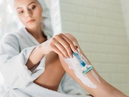 Žena noge brijanje young woman shaving leg in bathroom