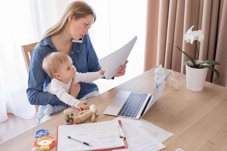 Working mom talking on the phone with child in her lap Mama Beba Rad od kuće Working mom talking on the phone with child in her lap Mama Beba Rad od kuće