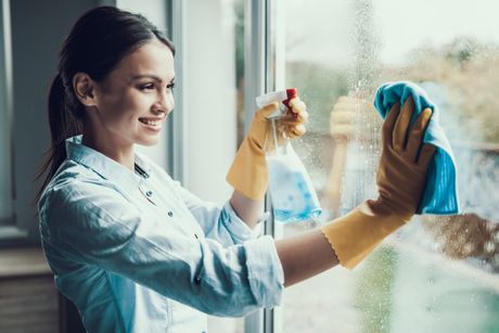 Pranje prozori prozora, sređivanje stana, žena čisti