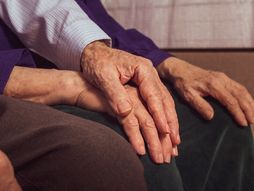 Stariji par se drži za ruke, starci, stari bračni par