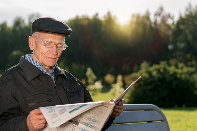 Penzioner čita novine u parku