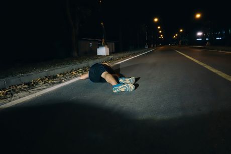 Čovek muškarac leži na ulici putu noć