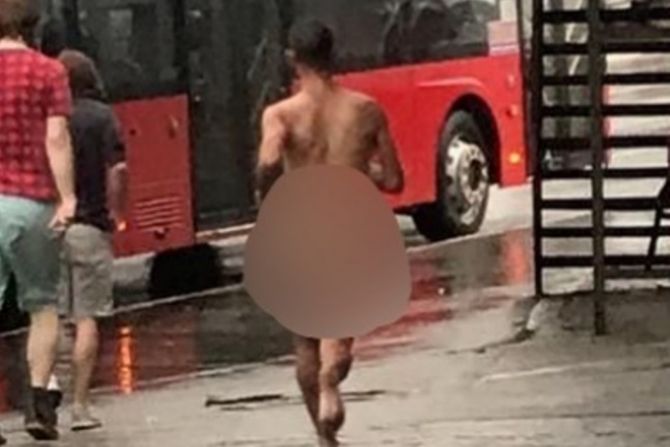 Nag muškarac trči po kiši za autobusom Nag muškarac trči po kiši za autobusom