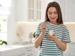 Žena jede, jogurt, pavlaka, kefir