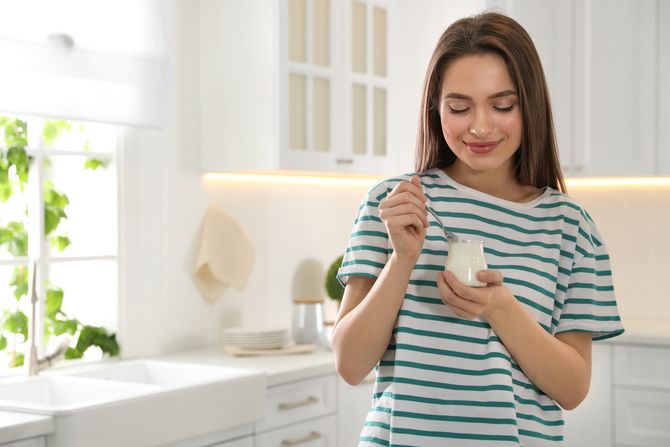 Žena jede, jogurt, pavlaka, kefir Žena jede, jogurt, pavlaka, kefir