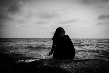 Tužna depresivna devojka žena sedi na plaži plaža usamljenost tuga