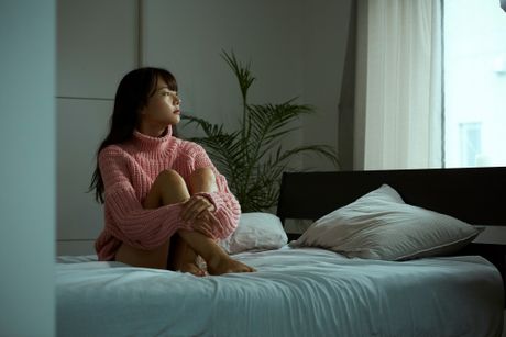 Mlada žena azijatkinja na krevetu