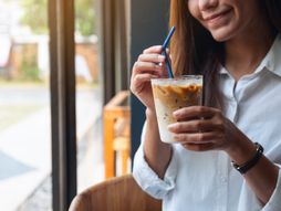 Devojka pije ledenu kafu kafa plastična slamčica