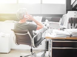 Čovek priča telefonom, noge na stolu,  kancelarija, posao