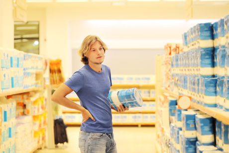 Čovek kupuje u supermarketu i čita informacije o proizvodu