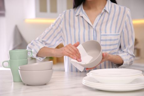 kuhinja, kuhinjsko posuđe, tanjiri, žena pere briše  tanjire ubrusom