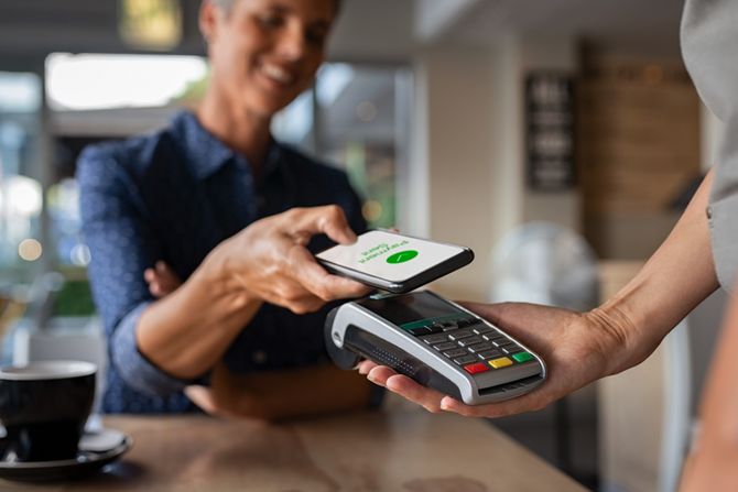 Žena plaća račun mobilni i elektronsko plaćanje NFC tehnologija Žena plaća račun mobilni i elektronsko plaćanje NFC tehnologija
