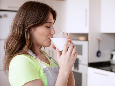 mlada žena pije čašu mleka