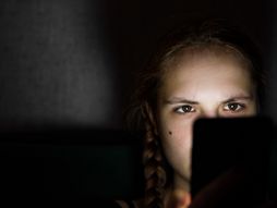 Devojčica na telefonu u tamnoj sobi