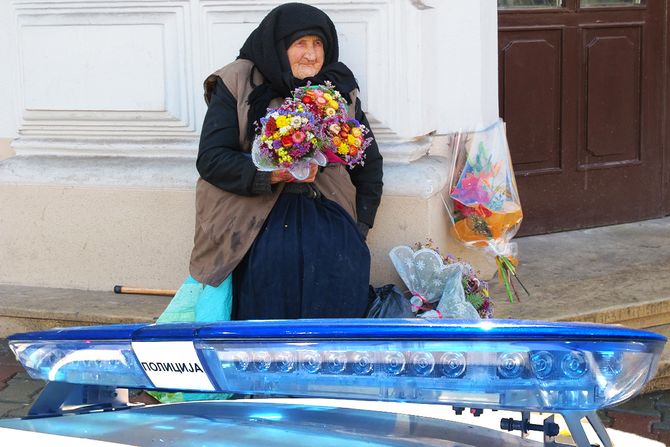 Starica na ulici prodaje cveće, policija