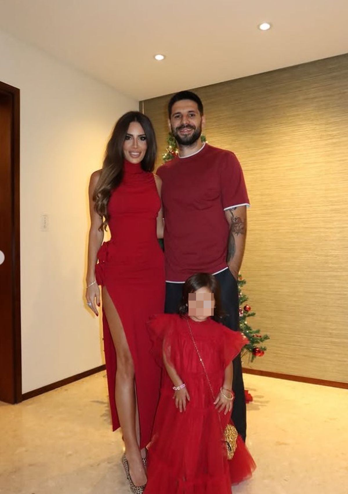 Mitrović joj drži ruku na: Fudbaler sa suprugom i decom slavio Novu godinu, Kristina grmela u crvenoj haljini