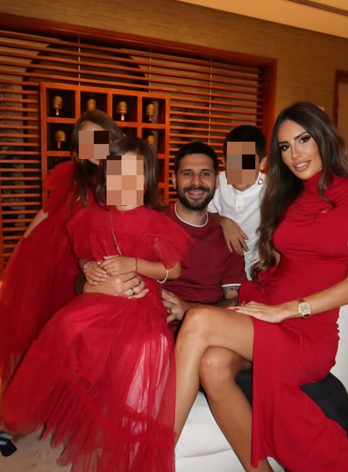 Mitrović joj drži ruku na: Fudbaler sa suprugom i decom slavio Novu godinu, Kristina grmela u crvenoj haljini