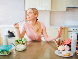 Zena jede u kuhinji, zdrava hrana, doručak