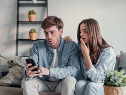 Bračni  par, muž žena ,mobilni, uplašeni, iznenađeni