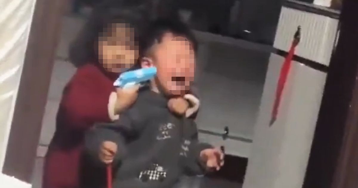 Devojčica s plastičnim pištoljem drži brata kao 