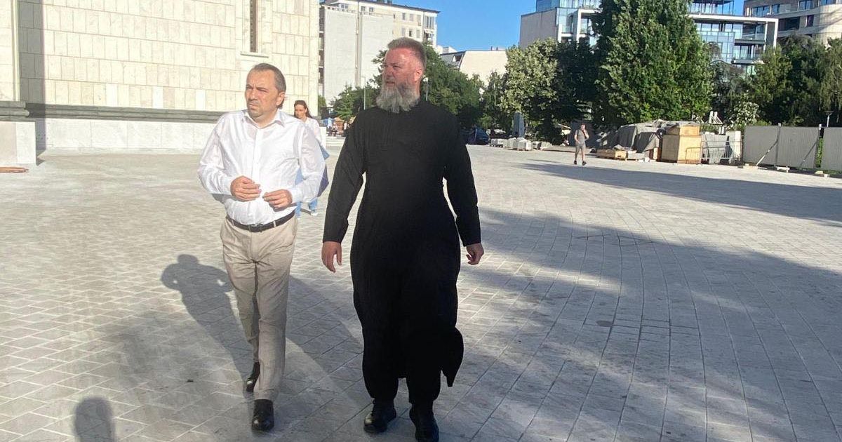 Священник Предраг Попович и государственный секретарь Нинослав Йованович среди верующих в Храме Святого Саввы